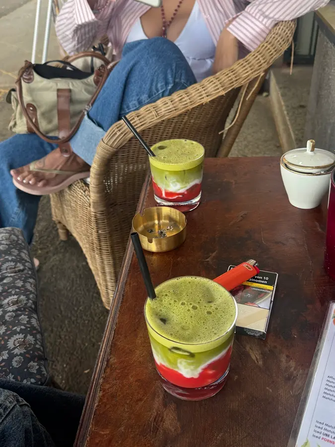Zwei Iced Matcha mit Erdbeerschicht auf einem Holztisch
